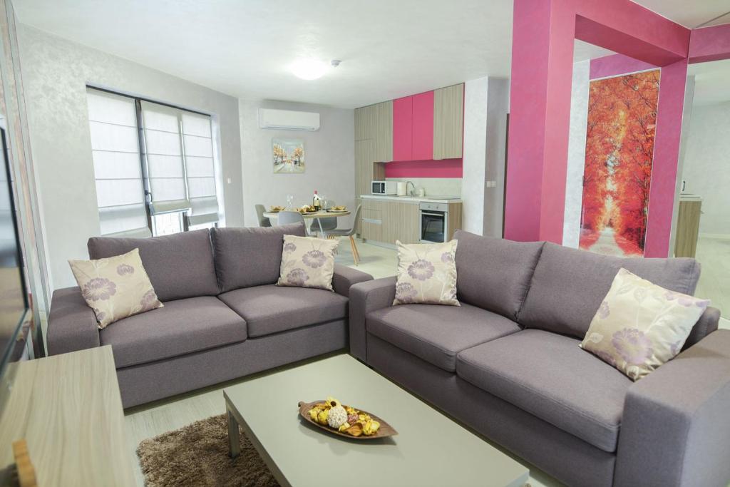 uma sala de estar com um sofá e uma mesa em Noris Apart with Garage em Plovdiv