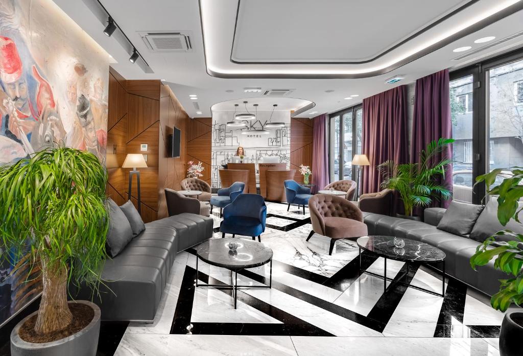 a lobby with a couch and chairs and tables at Sky Hotel in Belgrade