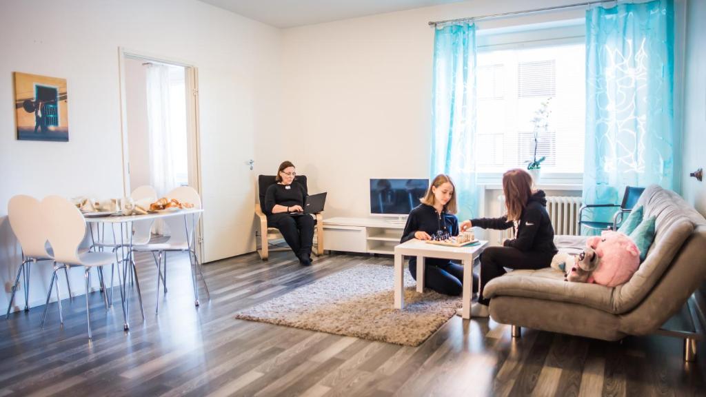 un groupe de personnes assises dans un salon dans l'établissement Apartment Hotel Tampere MN, à Tampere