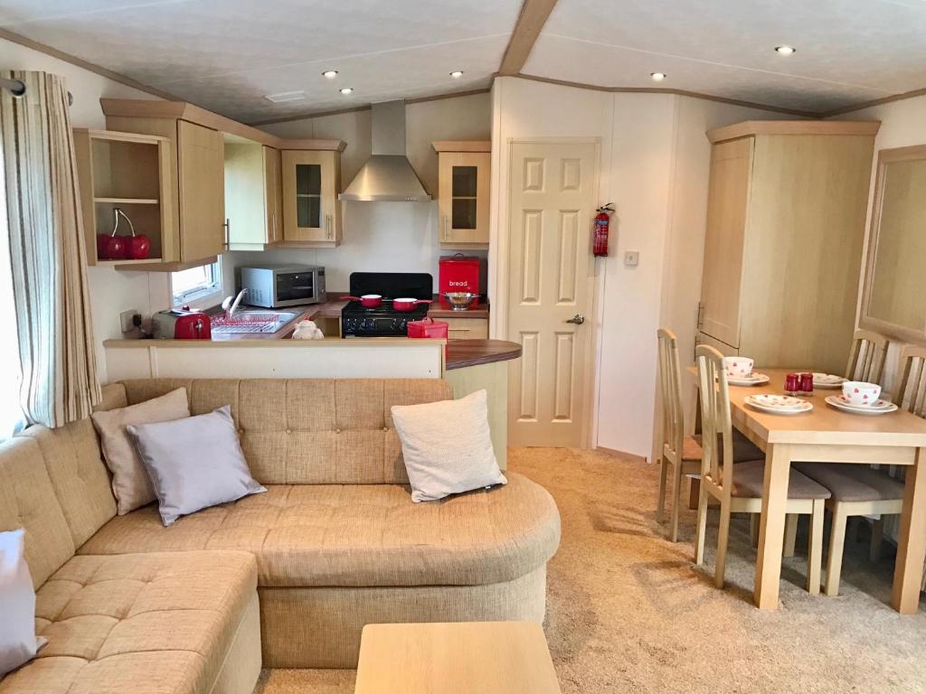 a living room with a couch and a table at Heacham Golden Sunset Caravan Pets go Free in Hunstanton