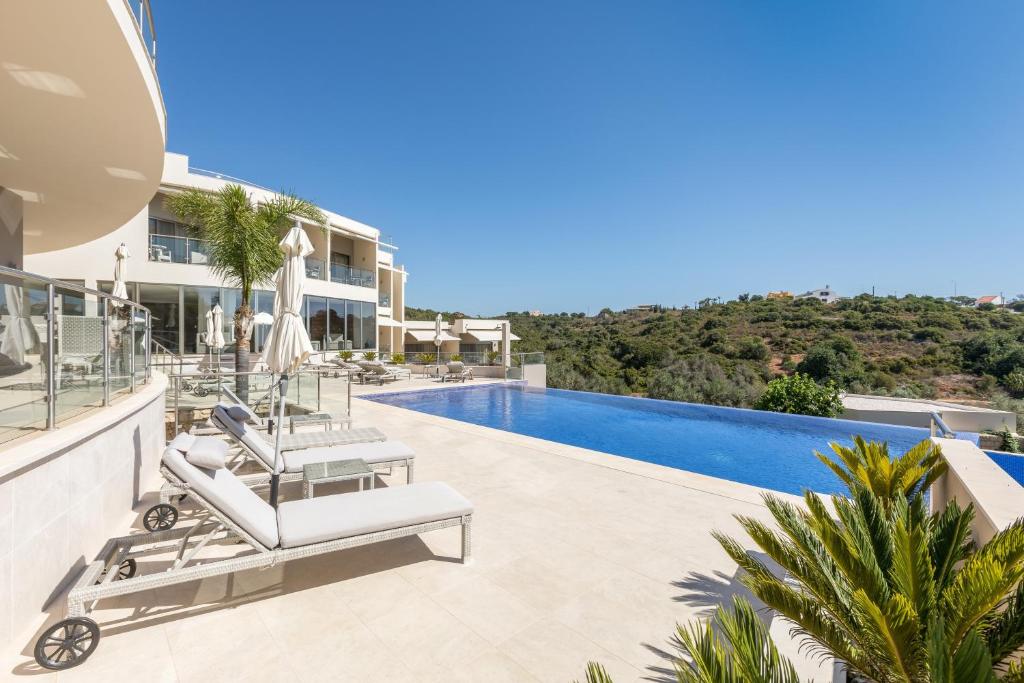 une image d'une villa avec une piscine dans l'établissement Caneiros Luxury House & Suites, à Ferragudo