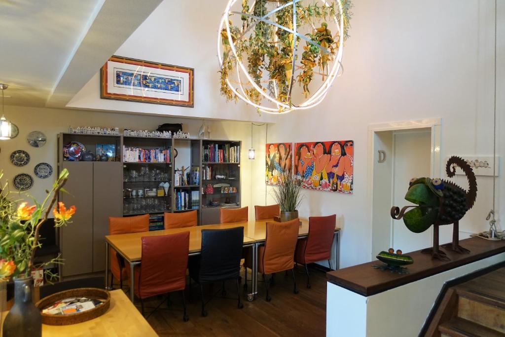 un restaurante con mesa, sillas y lámpara de araña en Bed&Breakfast Maasland en Maasland
