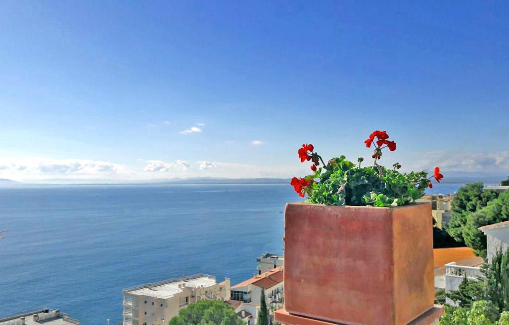a flower pot with red flowers on top of a building at Fantastico studio, vista mare, 5mn dalla spiaggia - Casa ArteVida in Roses