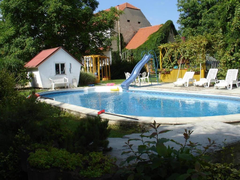 a swimming pool with a slide in a yard at Penzion u lípy in Jestřebí
