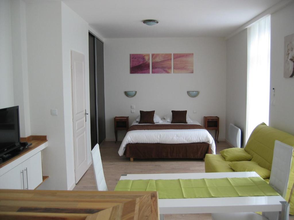 a bedroom with a bed and a green couch at Résidence Le Beau Site in Capvern