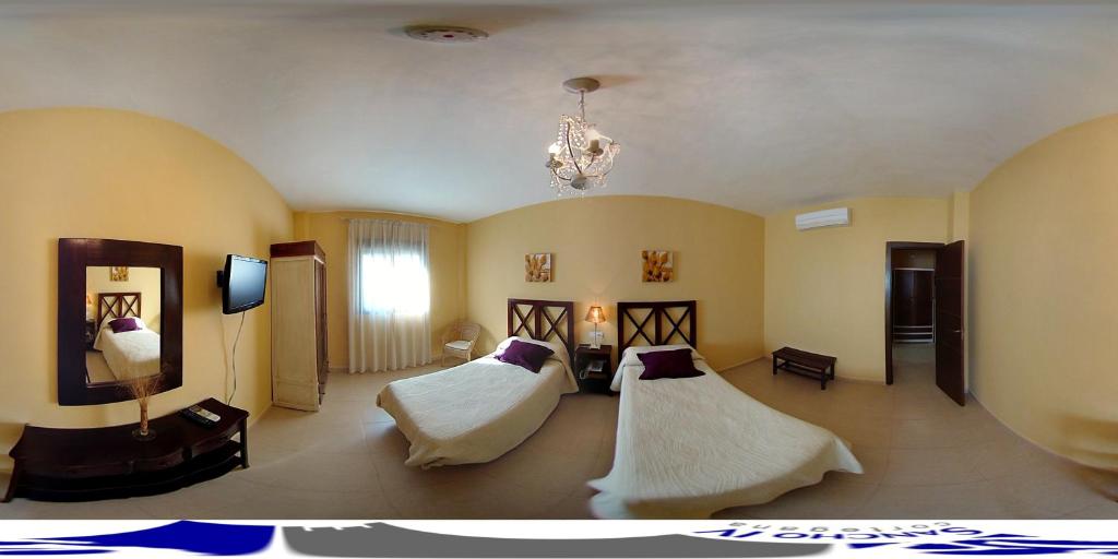 um quarto com 2 camas e um lustre em Apartamentos Sancho IV em Cortegana