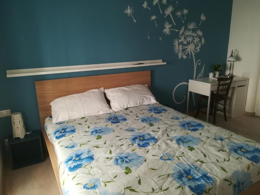 - une chambre avec un lit orné de fleurs bleues dans l'établissement Carta da zucchero, à Catane