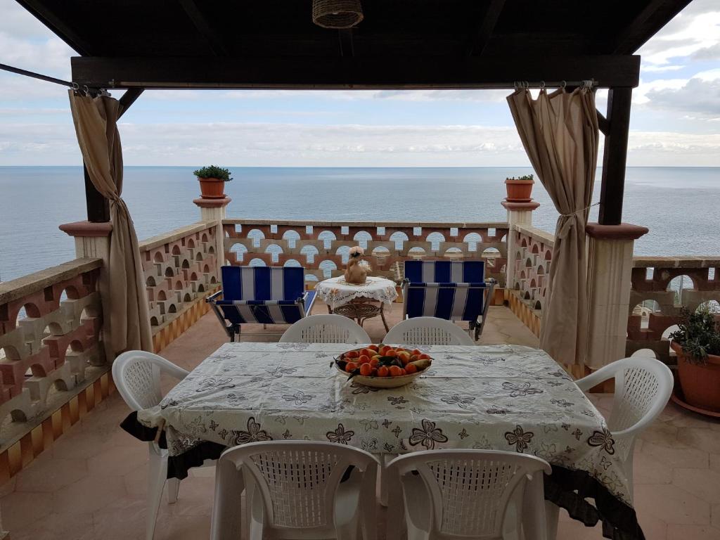 a table on a balcony with the ocean in the background at Salvia in Corsano