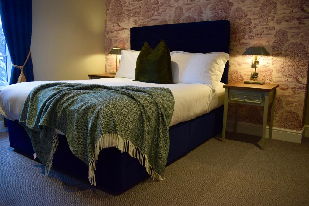 a bedroom with a large bed with a blue headboard at The Devonport in Darlington