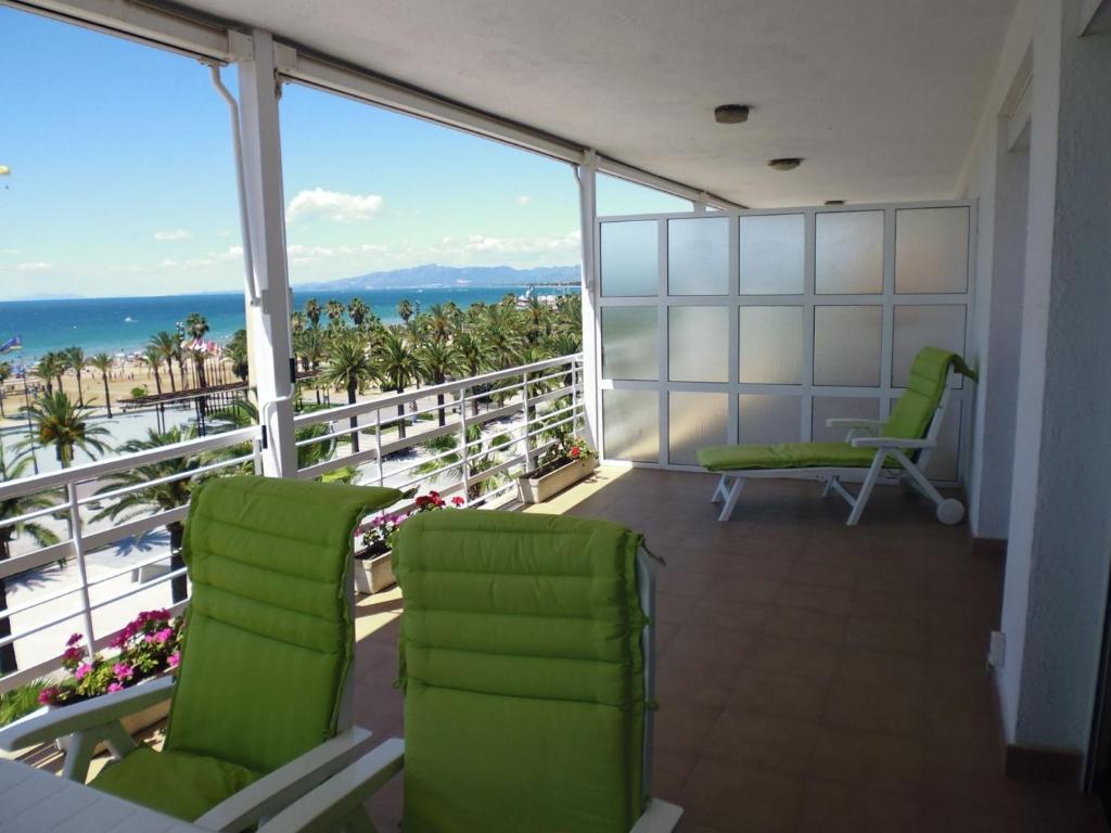 Un balcón con sillas verdes y vistas al océano. en Zeus Alexis Frontal, en Salou