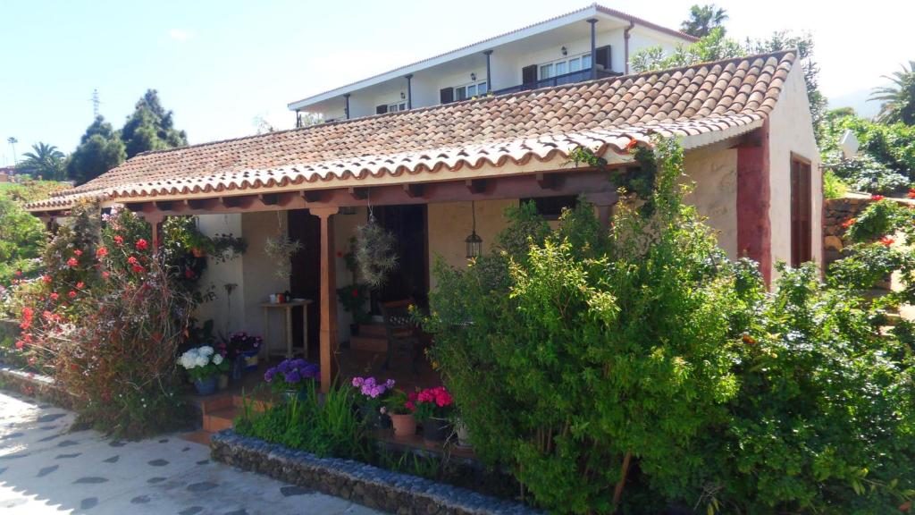 een klein huis met veel bloemen en planten bij Casa Grøn in Breña Alta