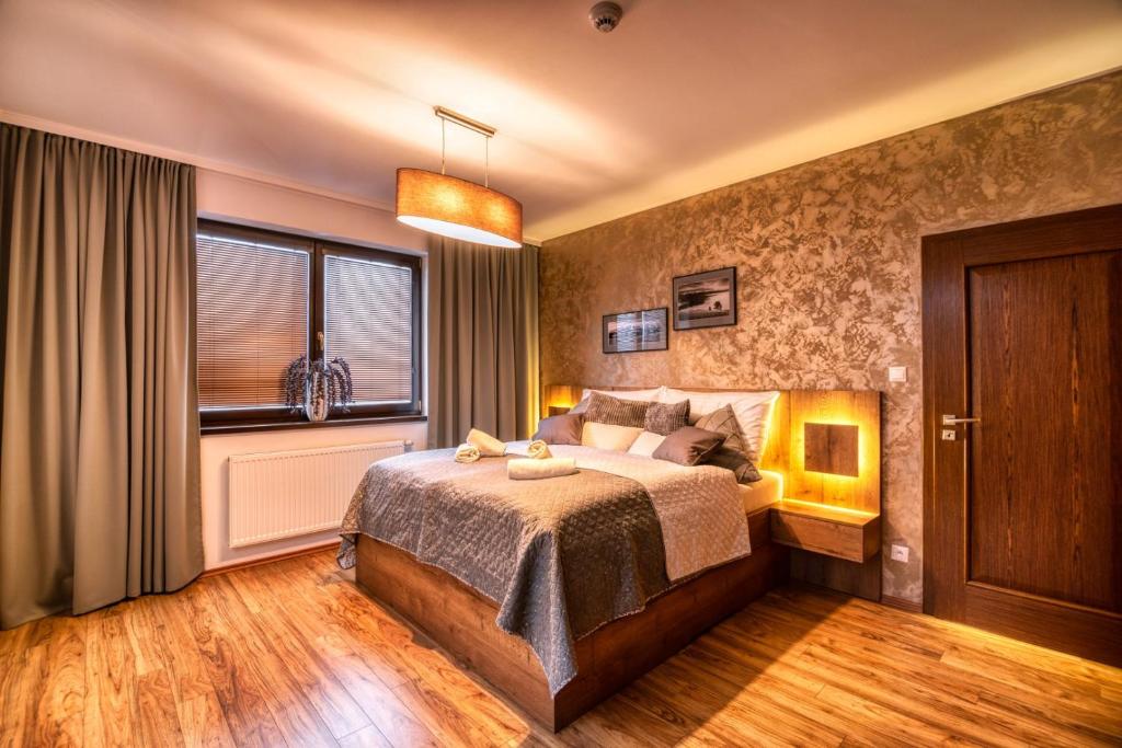 a bedroom with a bed and a window at Apartman Lio in Vysoke Tatry - Tatranska Lomnica.