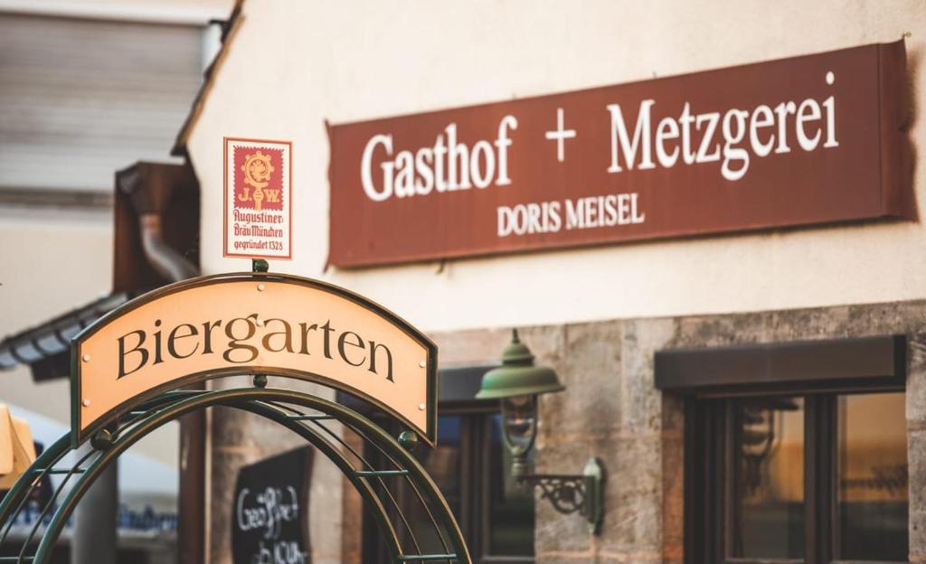 a sign in front of a store with a sign for aiger at Landgasthof Meisel in Kalchreuth