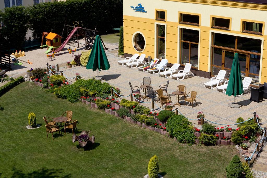 an aerial view of a patio with chairs and umbrellas and a playground at JANTAR-SPA Kompleks Wypoczynkowo-Rehabilitacyjny in Niechorze