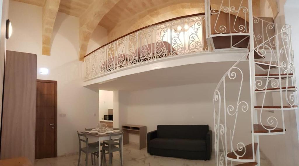 a spiral staircase in a living room with a couch and a table at Palazzo Leonardo in Il-Furjana