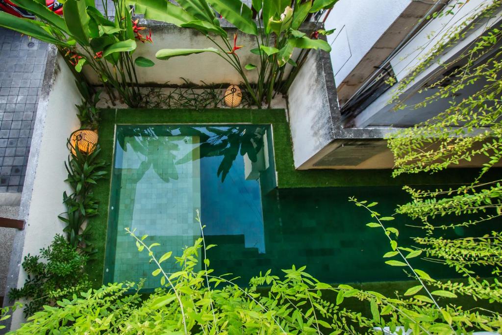 a window with plants on the side of a building at Kuta Suci Guesthouse in Kuta