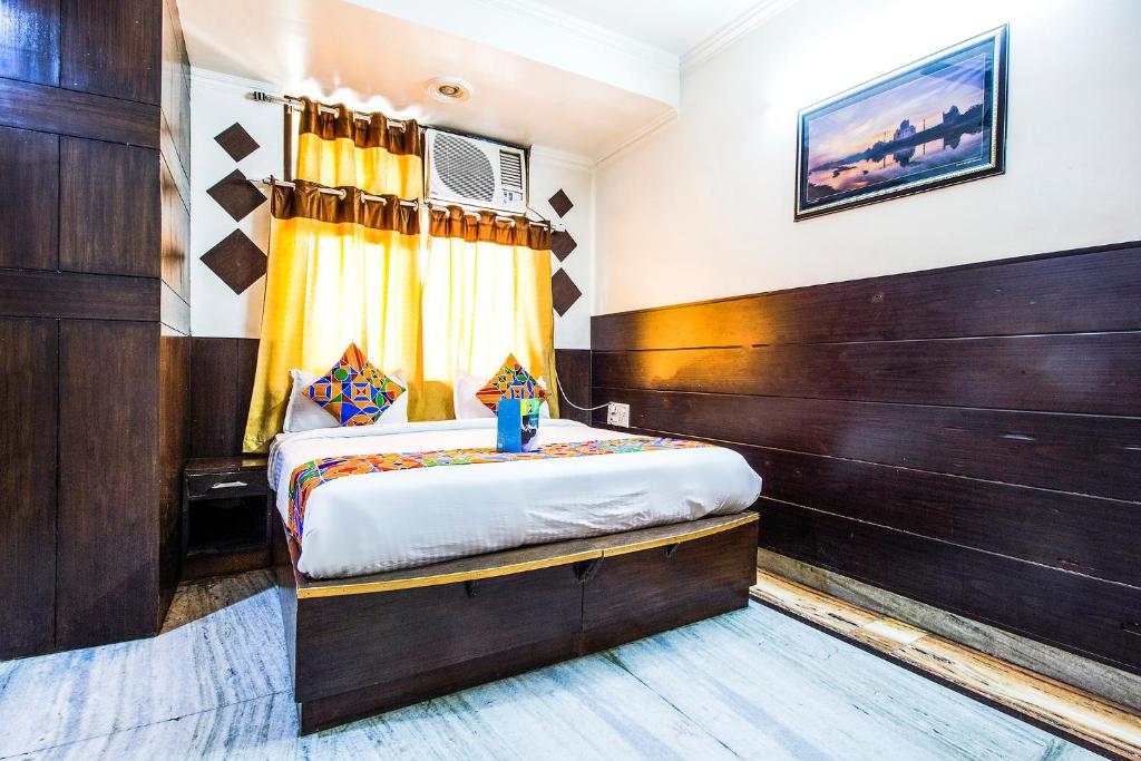 a bedroom with a bed with a wooden wall at FabExpress Alpine in Agra