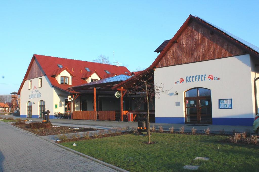 un gran edificio blanco con techo rojo en Slovácký dvůr s.r.o., en Ostrožská Nová Ves