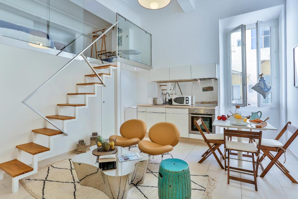 ein Wohnzimmer mit einer Treppe, einem Tisch und Stühlen in der Unterkunft Maison Bianchi - Duplex old town in Nizza