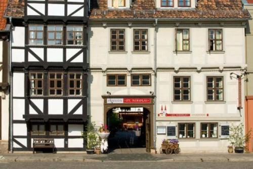 a large white building on a city street at Hotel Pension St Nikolai in Quedlinburg