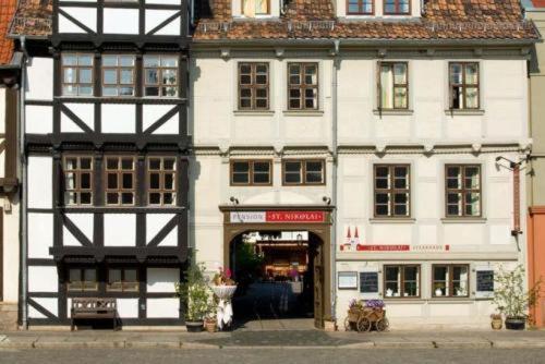 ein großes weißes Gebäude in einer Stadtstraße in der Unterkunft Hotel Pension St Nikolai in Quedlinburg