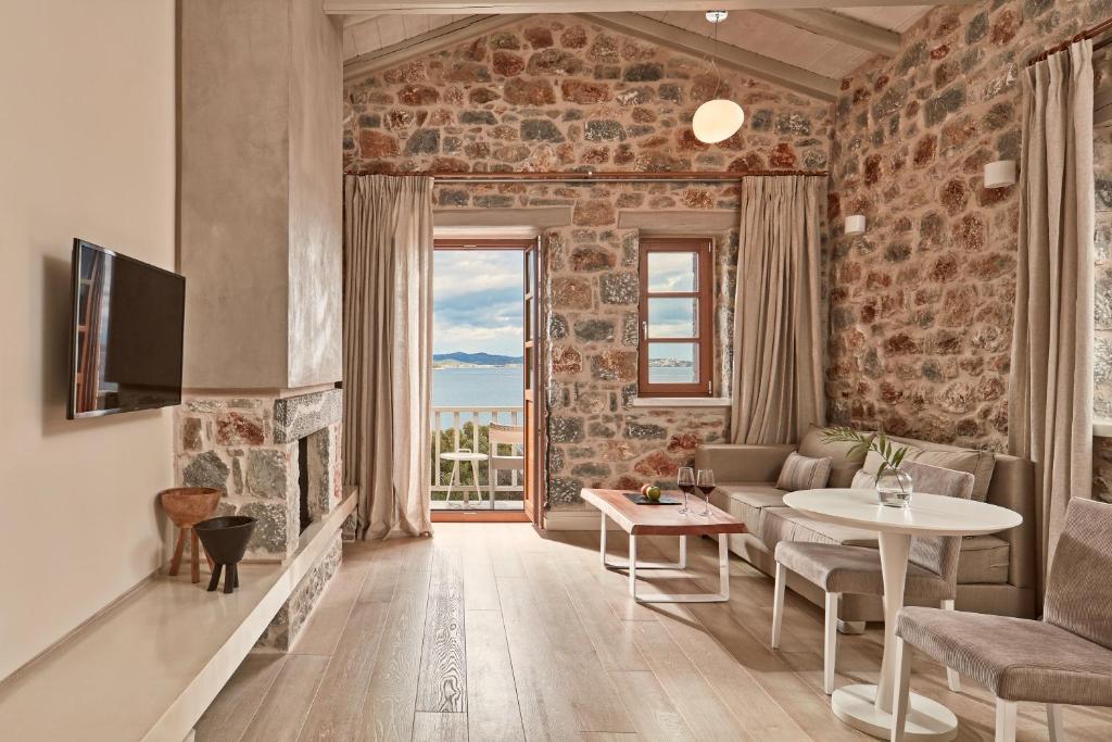 sala de estar con pared de piedra en 100 Rizes Seaside Resort- Small Luxury Hotels of the World en Gytheio