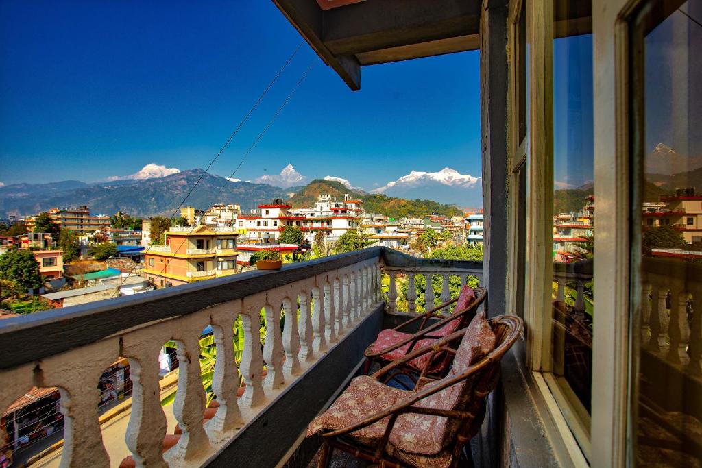 a balcony with a chair looking out at the mountains at Hotel Grand Holiday in Pokhara