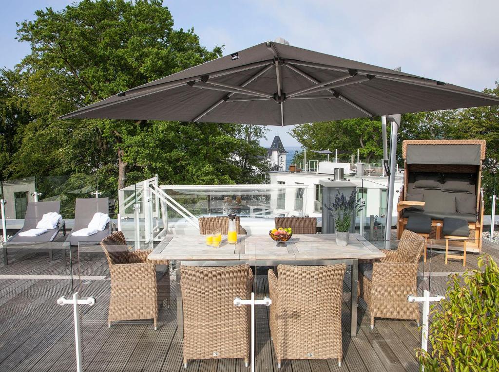 a table and chairs with an umbrella on a deck at Paradise Cloud***** in Binz