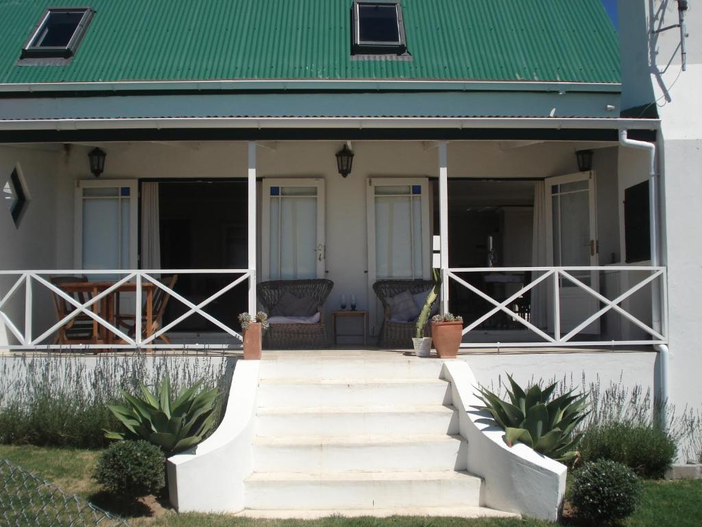 una casa con techo verde y escaleras en Aloe Cottage, en Darling