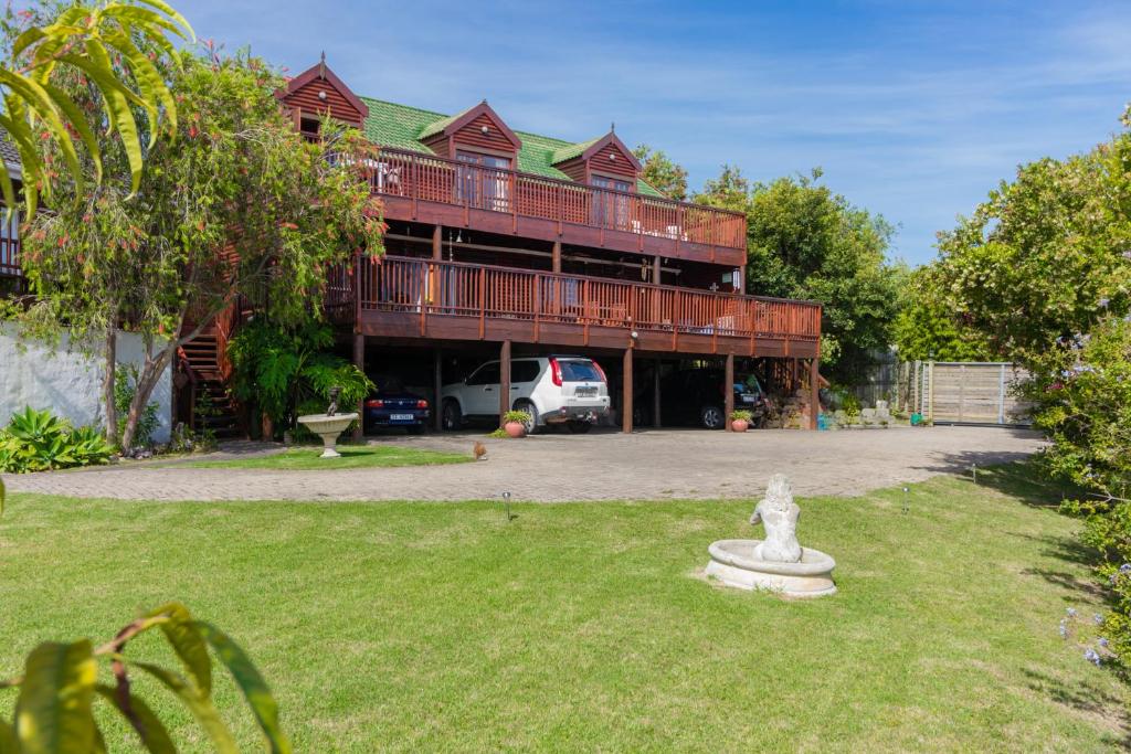 a large wooden building with a car parked in a yard at Stellata - inverter for guests' comfort in Knysna
