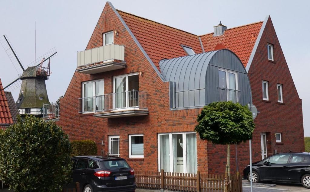 a red brick house with a metal dome on it at An´t Möhlen in Carolinensiel