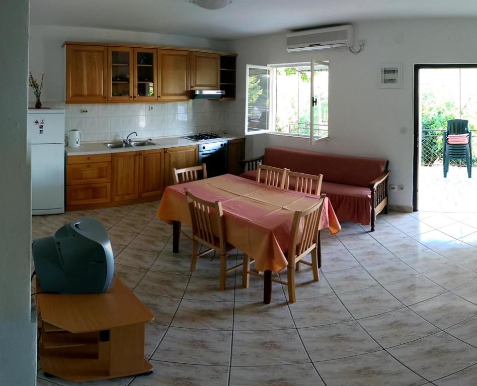 a kitchen and living room with a table and a couch at Apartmani Sandro in Ivan Dolac