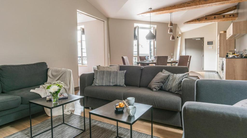 a living room with two couches and a table at Résidence Bastille Liberté in Paris