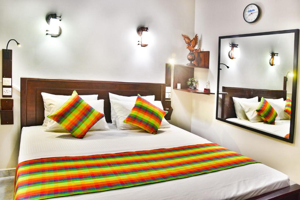 a bedroom with a bed with colorful striped pillows at Villa Hikka 08 in Hikkaduwa