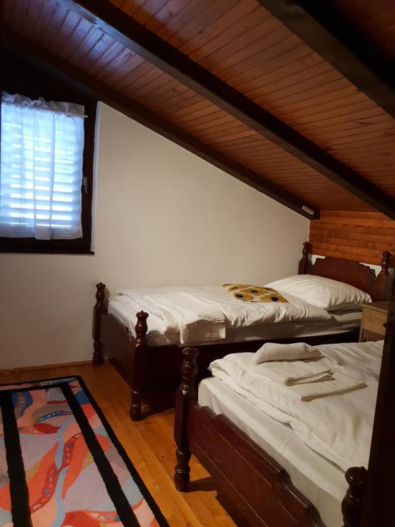 two twin beds in a room with a window at Svjetlost in Jahorina