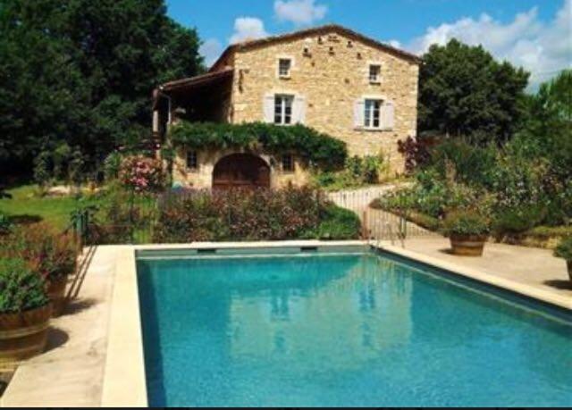 una grande piscina di fronte a una casa in pietra di Grand Vue Vert a Roubert
