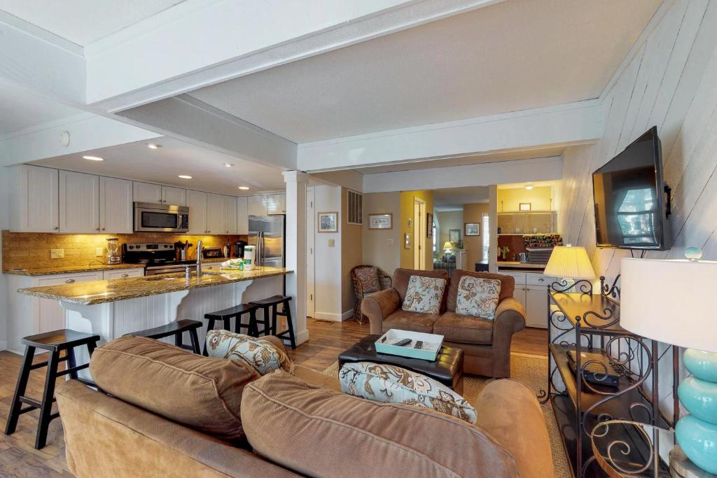 ein Wohnzimmer mit 2 Sofas und einer Küche in der Unterkunft Beachwalk 104 in Hilton Head Island