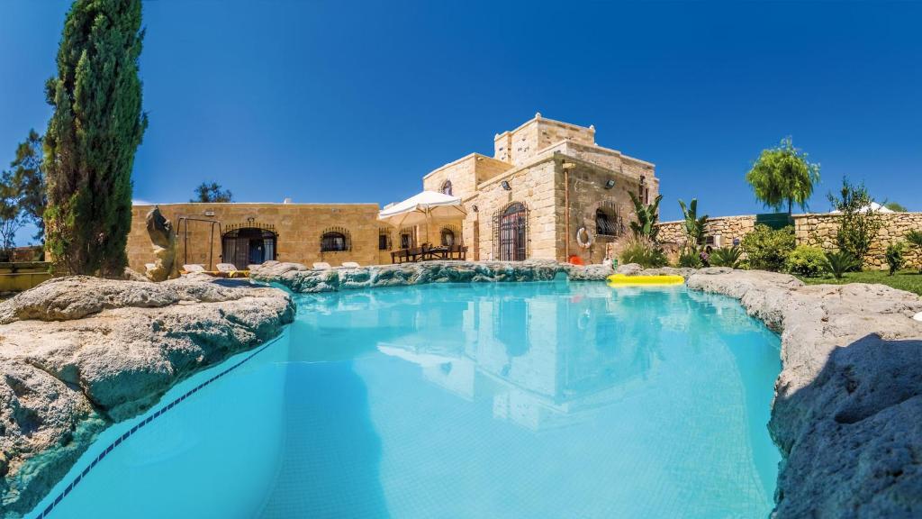 a swimming pool in front of a house at The Chateau in Żejtun