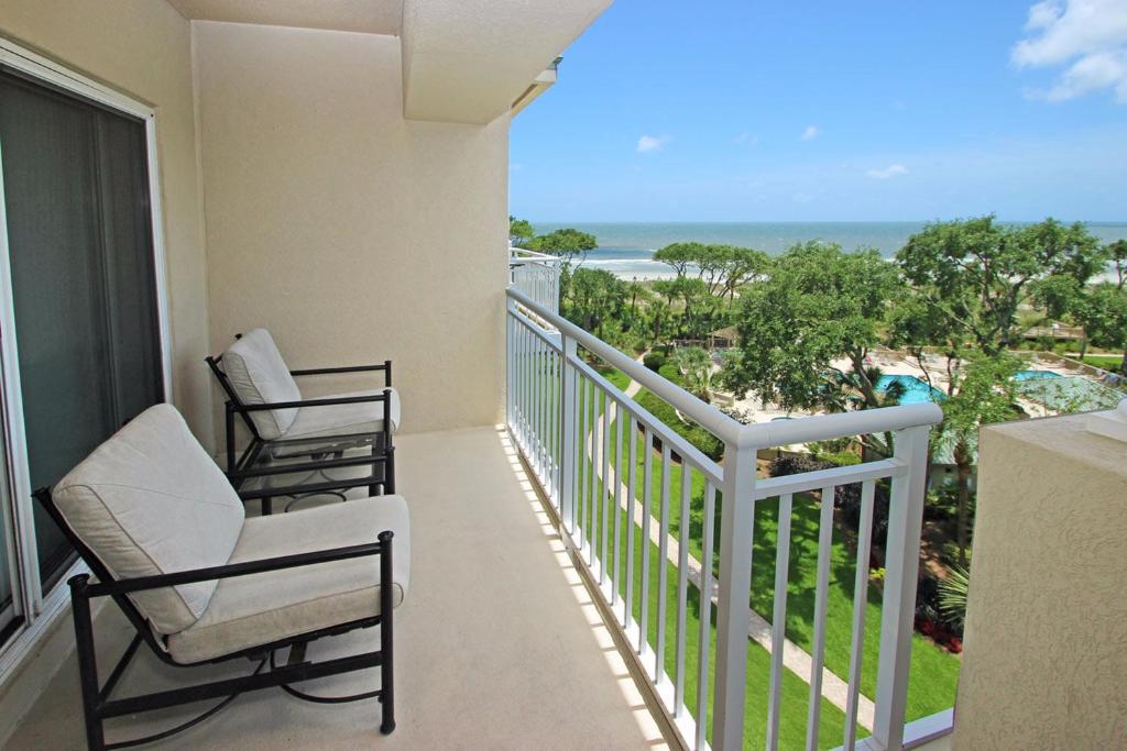 a balcony with two chairs and a view of the ocean at Hampton Place II in Hilton Head Island