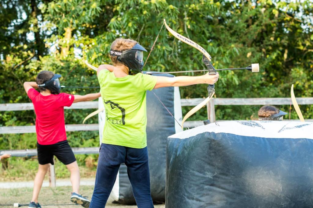 two young boys with helmets and shields playing with a bow and arrow at Les Ecolodges de l&#39;Orbière in Forcé