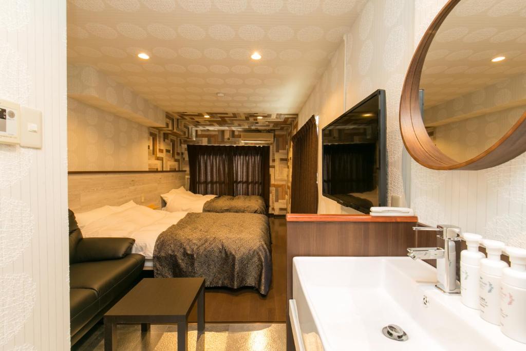 1 dormitorio con cama, lavabo y espejo en R Hotel Chiba sta 1min 2019 Open, en Chiba