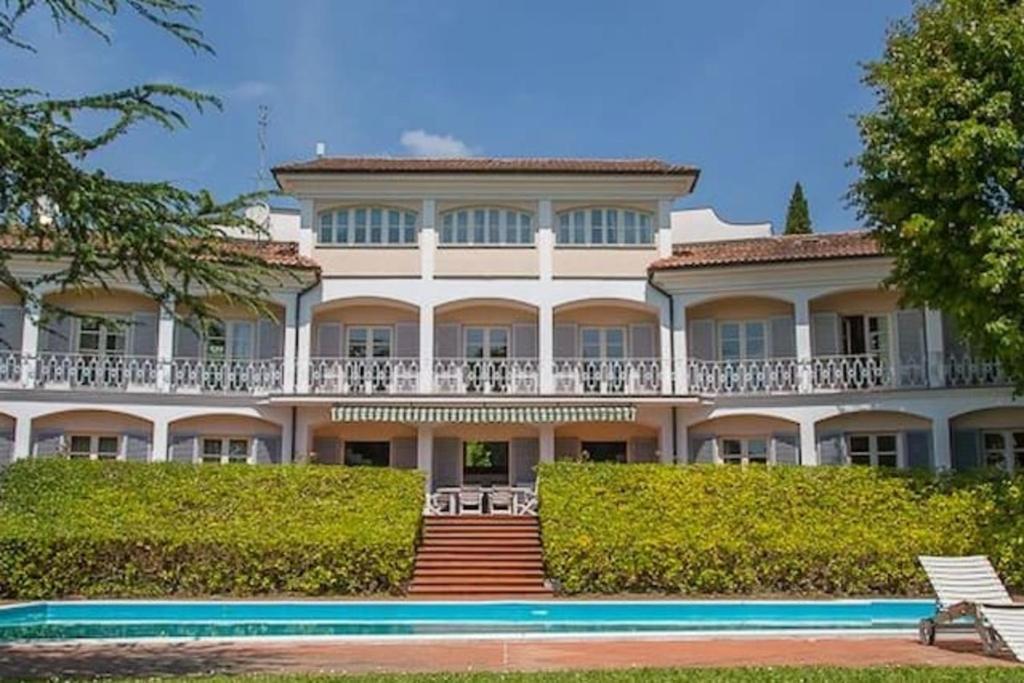 un gran edificio blanco con una piscina frente a él en Villa Bianca, en Lucca