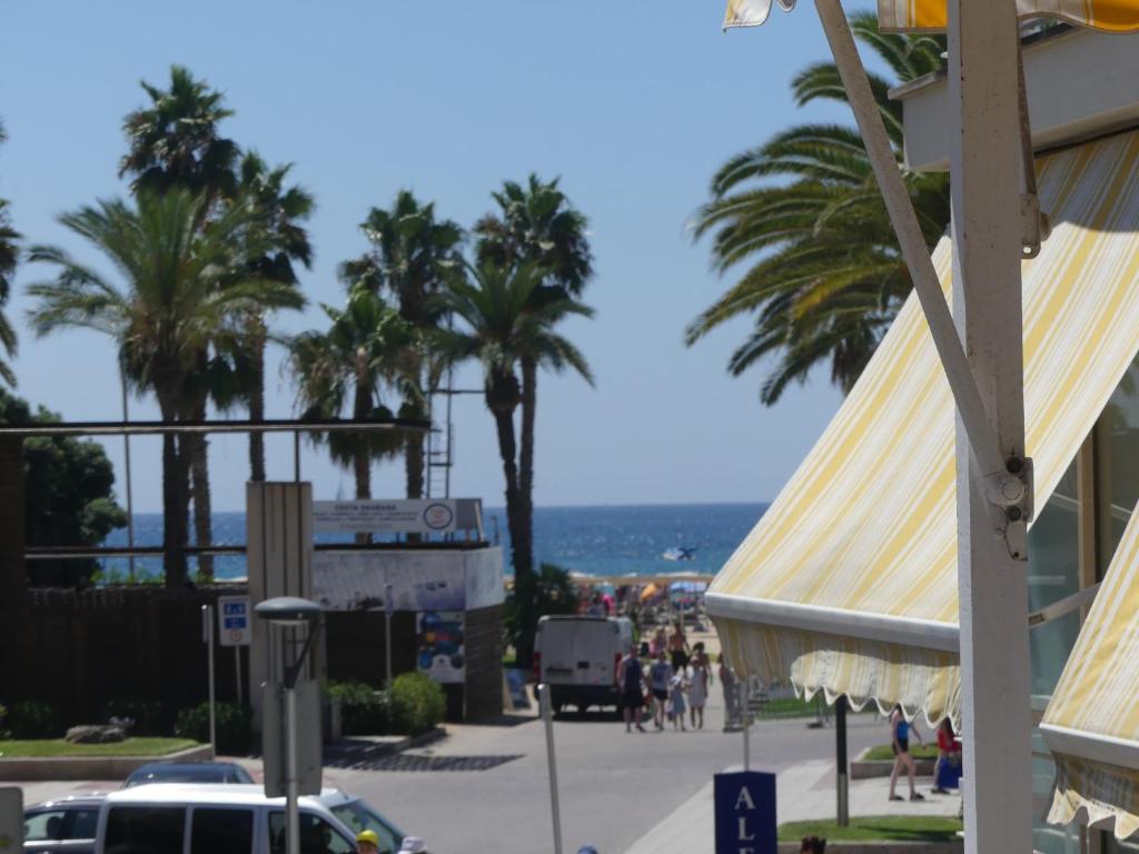 a street with palm trees and the ocean in the background at Zeus Alexis in Salou