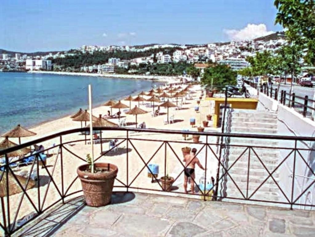 een strand met parasols en mensen op het strand bij Cosy Seaside Apartment in Kavala
