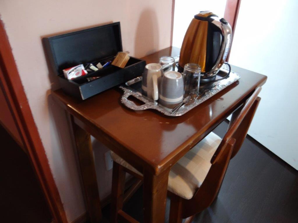 - une table avec une bouilloire et une boîte dans l'établissement Flossie B&B, à Pimville