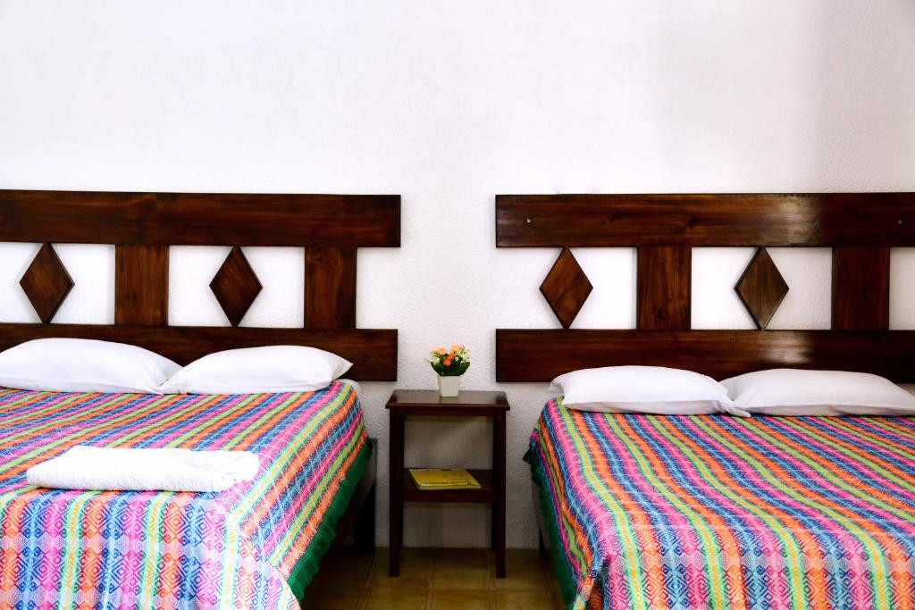 two beds sitting next to each other in a room at Hotel y Hostal Casa Don Alfonso in Valladolid