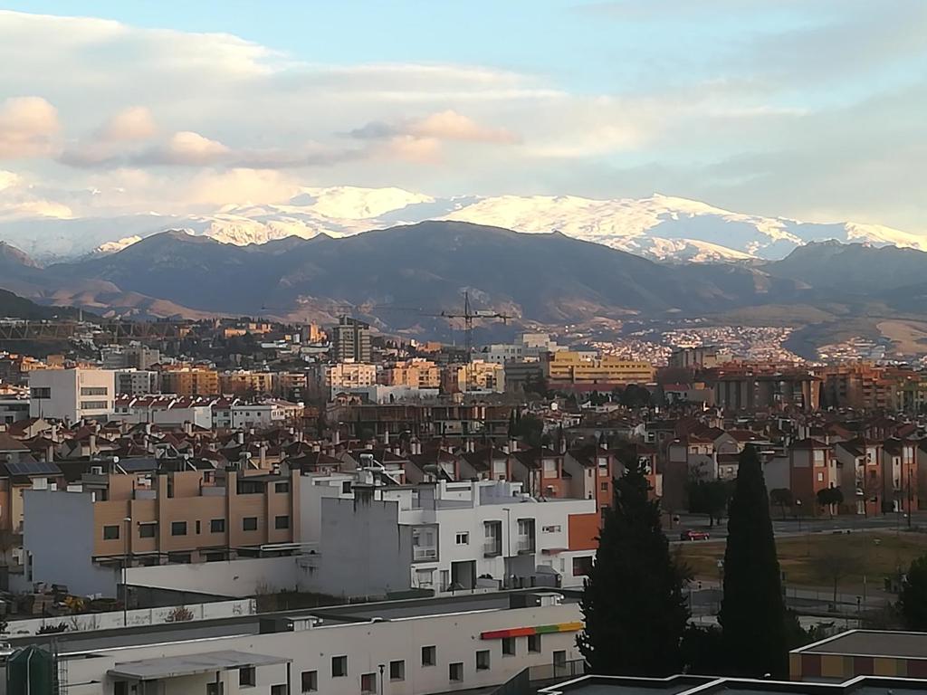 a view of a city with snow covered mountains at APARTAMENTO PERGAR I - 4 PERSONAS DESDE 35e-WIFI in Granada