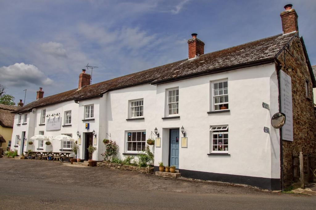 un grand bâtiment blanc avec une rue en face dans l'établissement Rams Head Inn, à Dolton