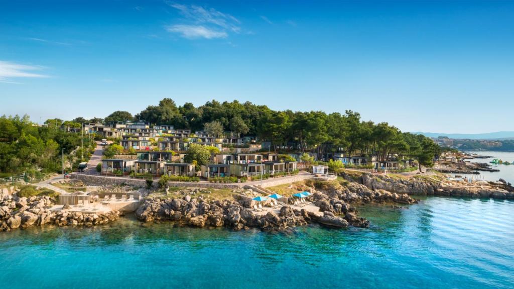 eine Luftansicht eines Resorts auf einer felsigen Insel im Wasser in der Unterkunft Ježevac Premium Camping Resort by Valamar in Krk