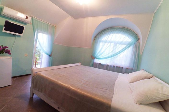 a bedroom with a large bed and a window at Pasuel in Zaliznyy Port